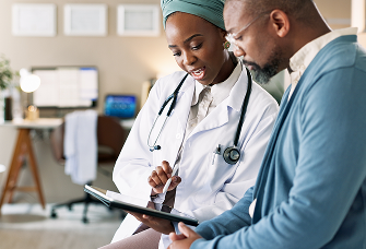 Nurse discussing healthcare information with patient. Actor portrayal.