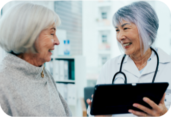 Patient and doctor smiling at each other. Actor portrayal.