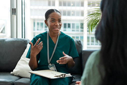 Nurse speaking with patient during appointment. Actor portrayal.